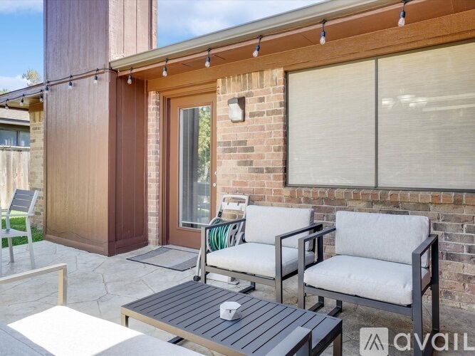 A patio with a table, two chairs and a bench.