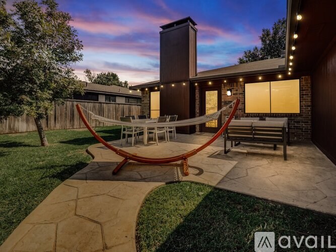 A backyard with a hammock and a patio area.