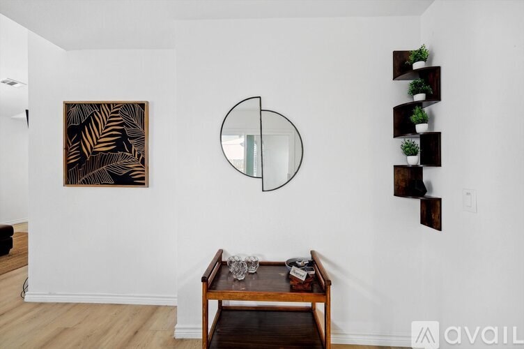 A living room with a brown coffee table and a large mirror on the wall.