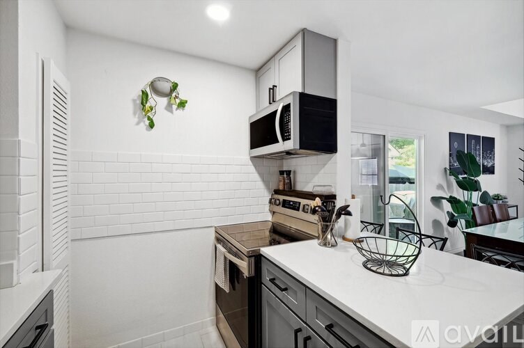 A kitchen with a white countertop and a microwave above it.
