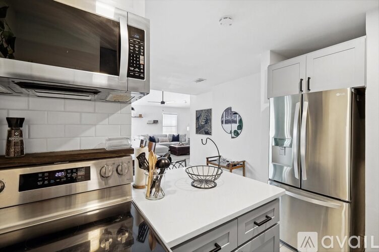 A modern kitchen with stainless steel appliances and white countertops.
