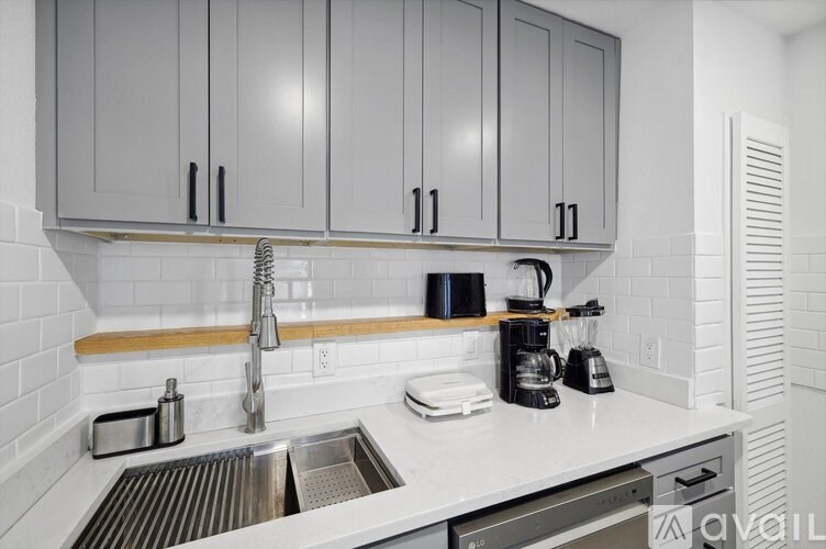 A kitchen with white cabinets and a white sink.