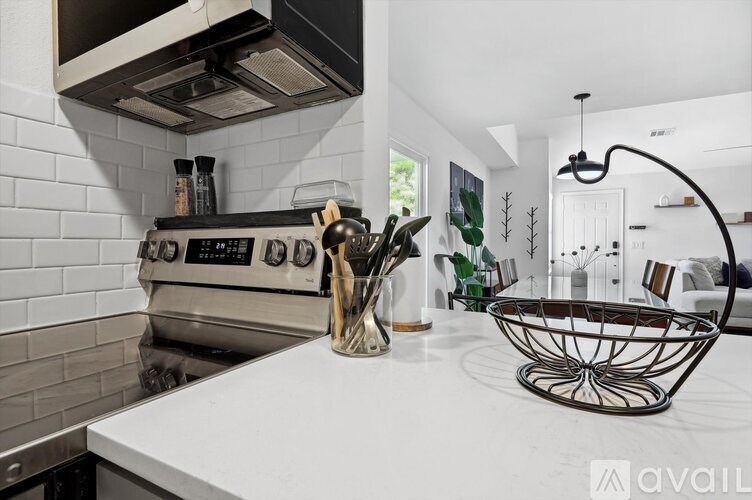 A modern kitchen with a white countertop and a stainless steel oven.
