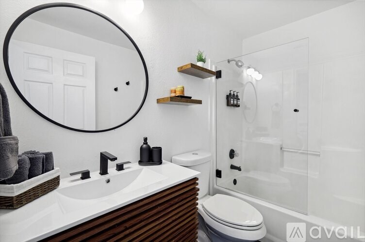 A modern bathroom with a white sink and toilet.