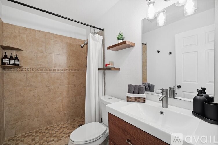 A bathroom with a toilet, sink, and shower.