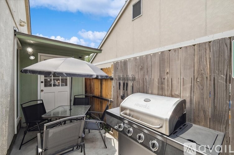 A backyard with a grill and a table set up.