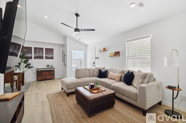 A living room with a brown rug, a white couch, and a brown coffee table.