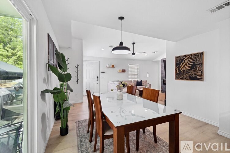 A modern dining room with a long table and chairs.