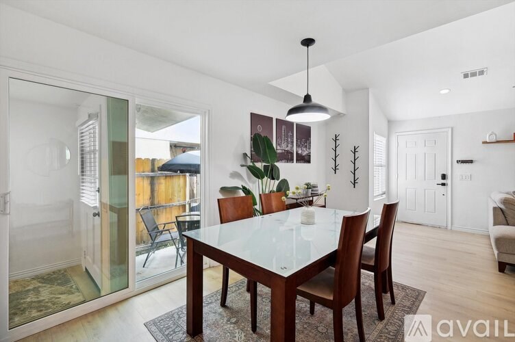 A dining room with a glass table and chairs.