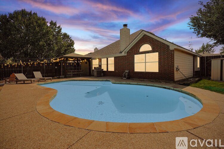 A backyard with a pool and a house.