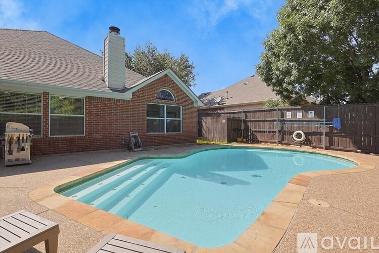 A backyard with a pool and a house.