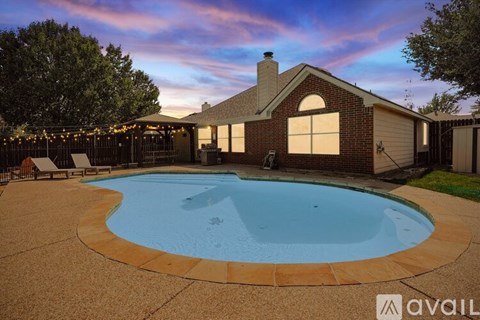 A backyard with a pool and a house.