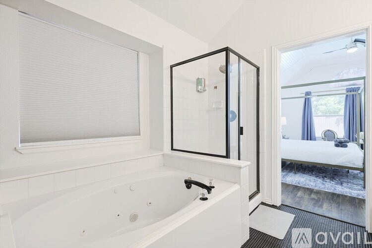 A white bathroom with a tub and a window.