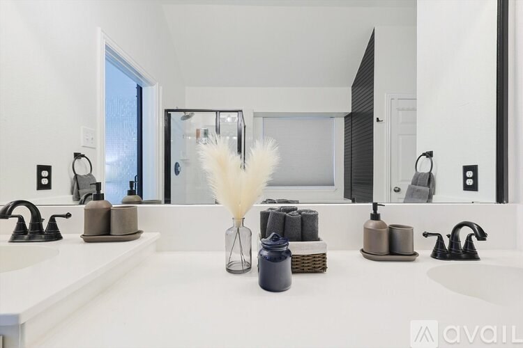 A bathroom with a white countertop and a large mirror.