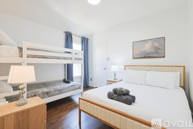 A bedroom with a large bed and a bunk bed.