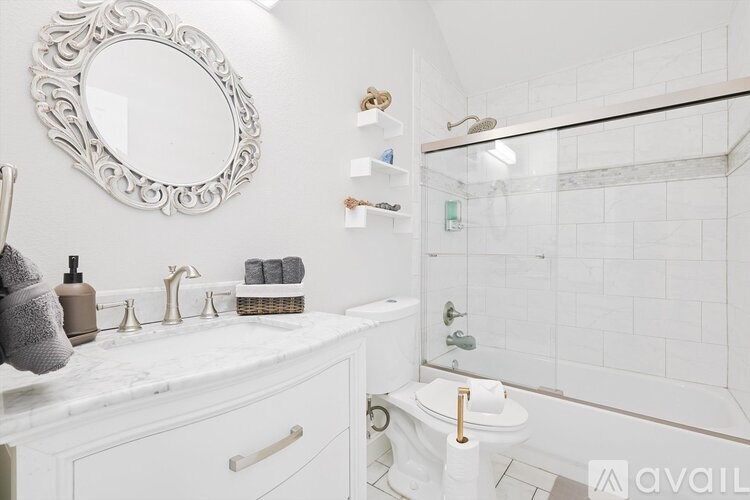 A bathroom with a white toilet, sink, and a mirror.