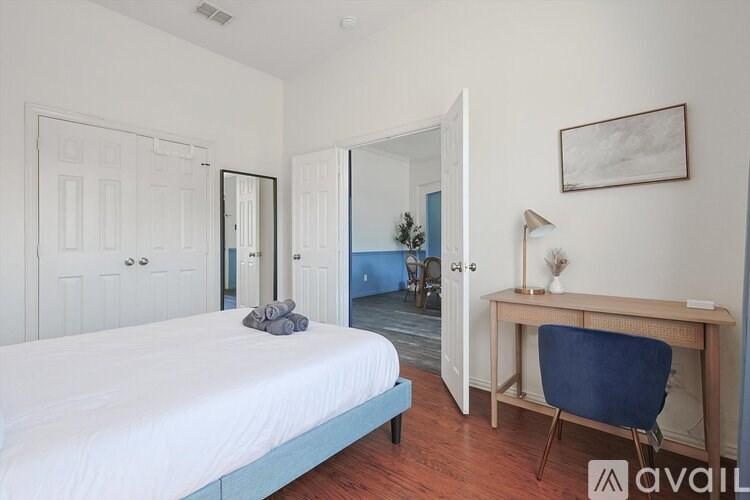 A bedroom with a bed, desk, and chair.