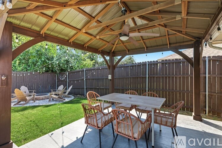 A patio with a table and chairs under a roof.