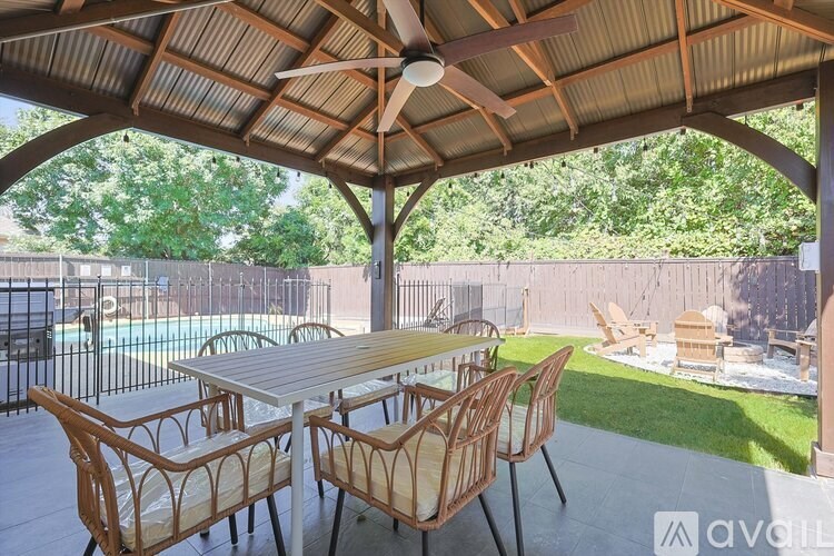 A patio with a table and chairs under a roof.