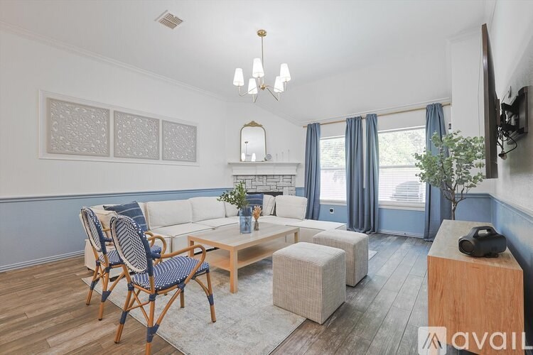 A living room with a white couch, blue chairs, and a wooden coffee table.