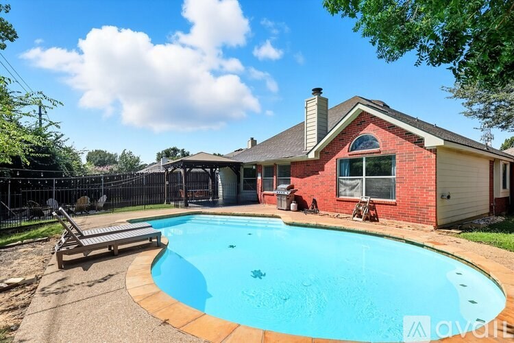 A patio area with a wooden pergola and string lights.