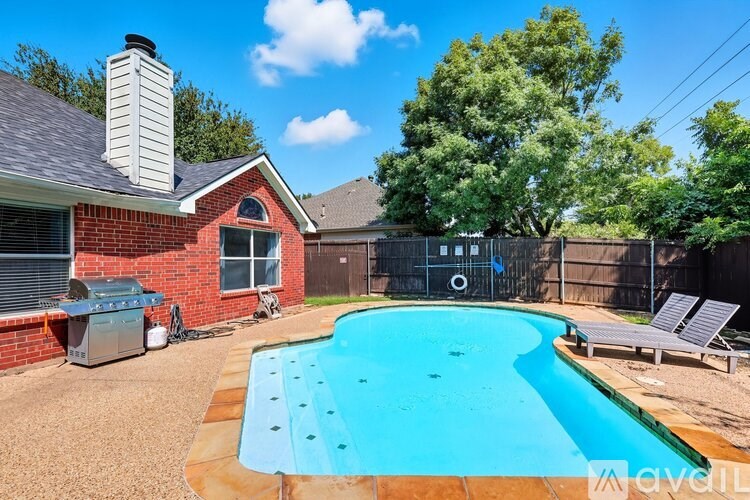 A patio with a grill and a covered table.