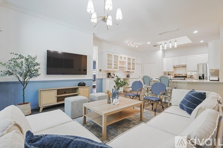 A living room with a white couch, a wooden coffee table, and a blue tree.