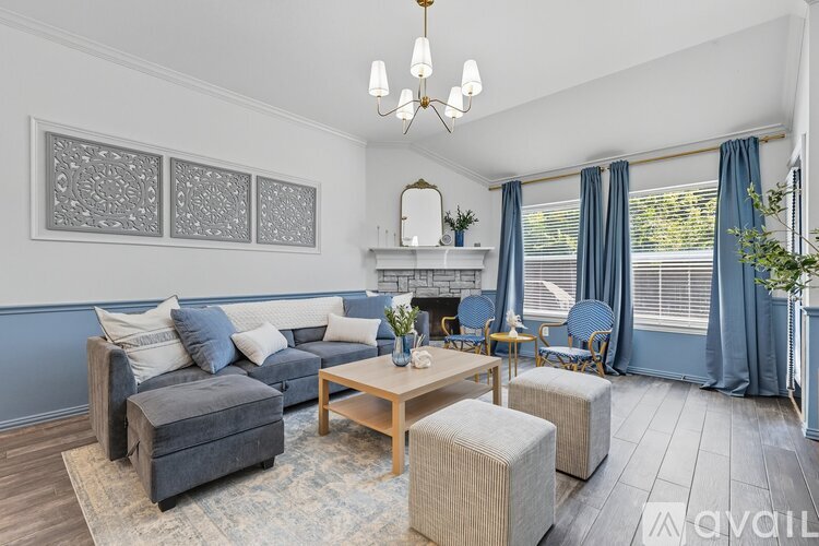A living room with a white couch and blue chairs.