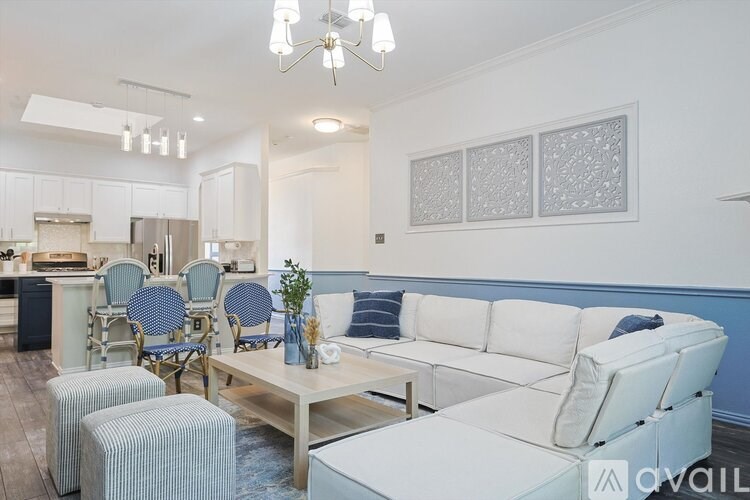 A living room with a white couch and blue chairs.