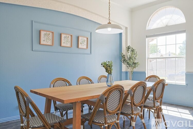 A dining room with a wooden table and chairs.