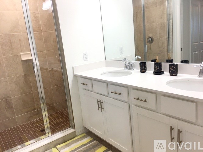 A bathroom with a white sink and a glass shower door.