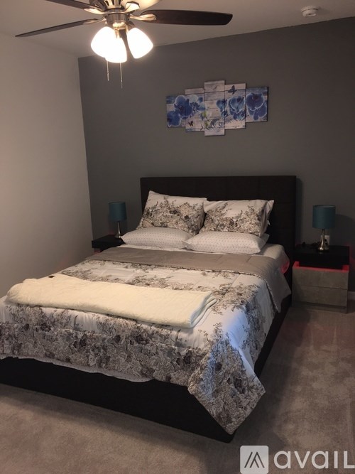 A bedroom with a large bed and a ceiling fan.