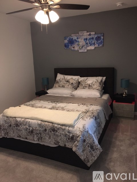 A bedroom with a large bed and a ceiling fan.