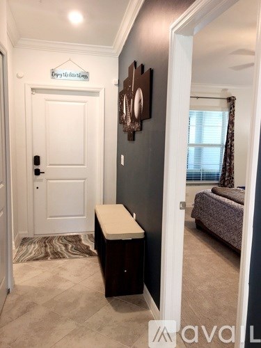 A hallway with a white door and a brown bench.