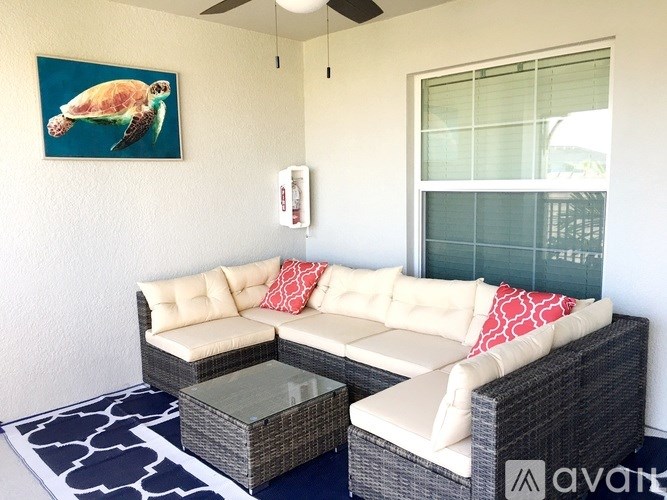 A living room with a sofa and a turtle picture on the wall.