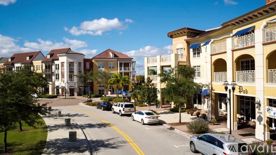 A street view of a town with cars parked on the side of the road.