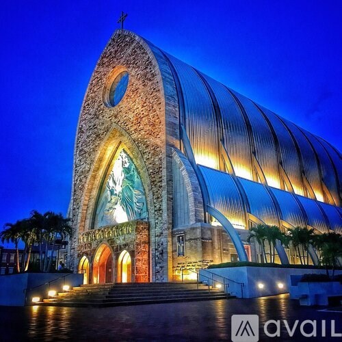 A modern church with a large statue in the entrance.