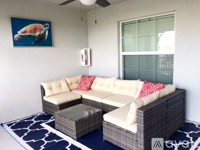 A patio with a white couch and a turtle picture on the wall.