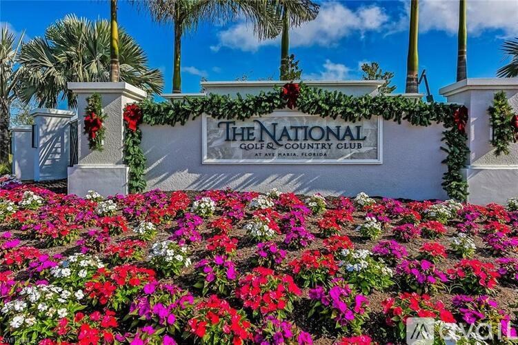 The National Golf and Country Club sign is adorned with red poinsettias.