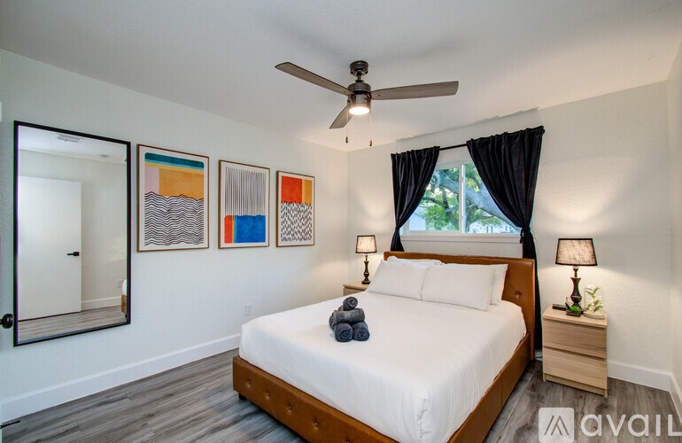 A bedroom with a bed, nightstand, and a ceiling fan.