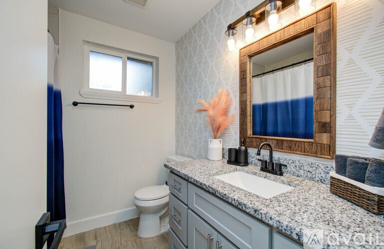A bathroom with a toilet, sink, and mirror.