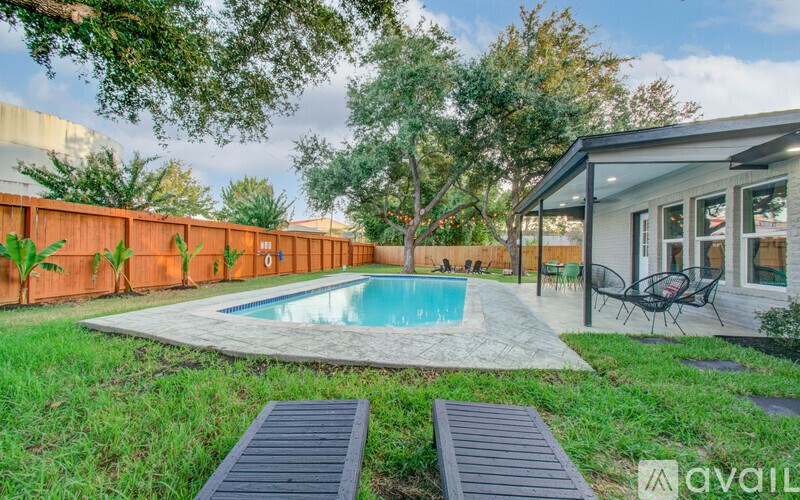 A backyard with a pool and a deck.