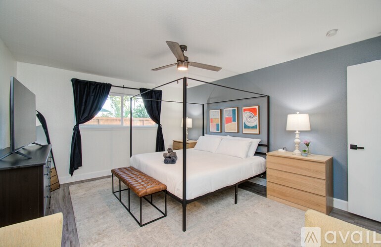 A bedroom with a bed, a dresser, and a ceiling fan.