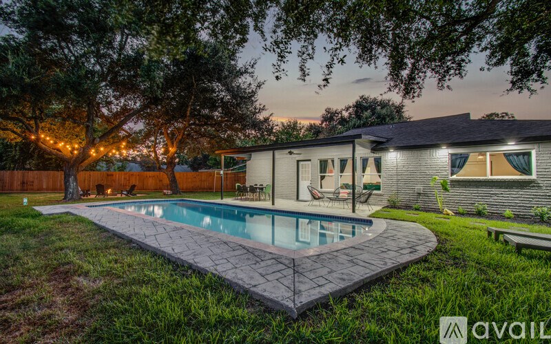 A backyard with a pool and a house with the name "INVI" on it.