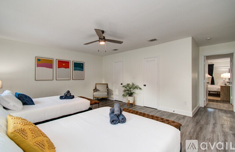 A bedroom with a large bed and a ceiling fan.