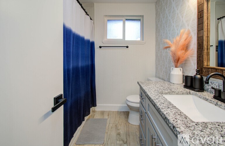 A bathroom with a toilet, sink, and shower.