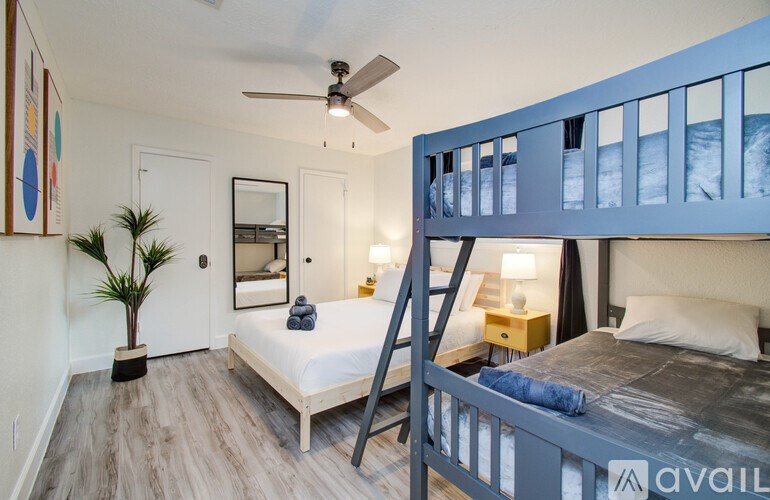 A bedroom with a bunk bed and a ceiling fan.