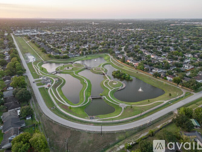 A park with a large pond and a racetrack.