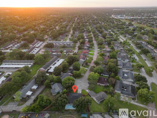 An aerial view of a neighborhood with a red marker indicating a specific location.
