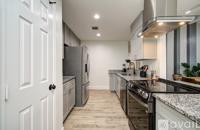 A modern kitchen with a refrigerator, oven, and cabinets.